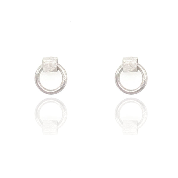 Mini City Earrings made of brushed sterling silver hollow cubes with polished sterling silver circles that move through them, featuring clean lines and a bold, kinetic design.