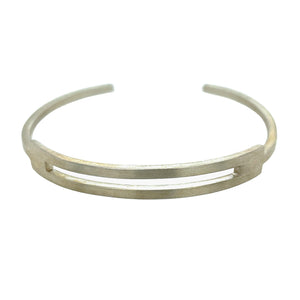 Cuff style bracelet in Sterling silver wit a brushed finish. The top part of the bracelet shows 2 bars with a space just as wide as the bars in between them. Those 2 bars make up about 1/3 of the overall bracelet. At each end of those top bars, they are connected with a single bar in between the 2 top bars. The bars are made out of a square wire.