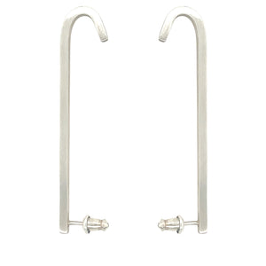 Image shows 2 upside down J shaped earrings made out of sterling silver and that has a matte brushed finish. Bullet style earring backs for added support. The Ear bars are made out of square wire, which gives this earring 4 flat sides.